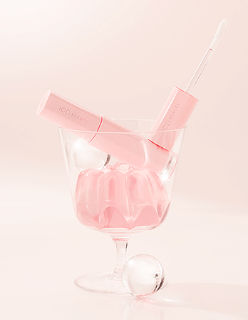 Riman ICD Beauty Glow Up Lip Oil in a glass, featuring glossy pink packaging and jelly-like texture for lip nourishment.