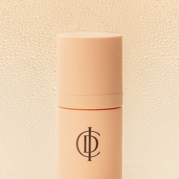 Riman ICD Makeup Set & Stay Spray in a mist bottle with a sleek design and droplets on a light background.