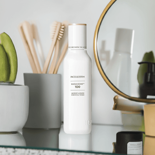 Incellderm Radiansome 100 Microfluidizer Essential Toner on a vanity table with skincare products and decor.