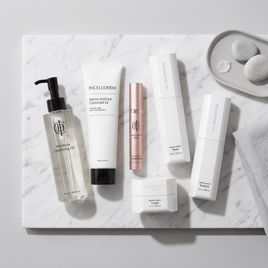 A six-piece skincare set from INCELDERM and RIMAN on a solid white background. The set includes a clear bottle of Moisture Cleansing Oil with a black pump, a white tube of Snow Enzyme Cleanser, a white bottle of Toner, a white bottle of Essence, a white jar of Cream, and a rose gold tube of Microblading Serum.