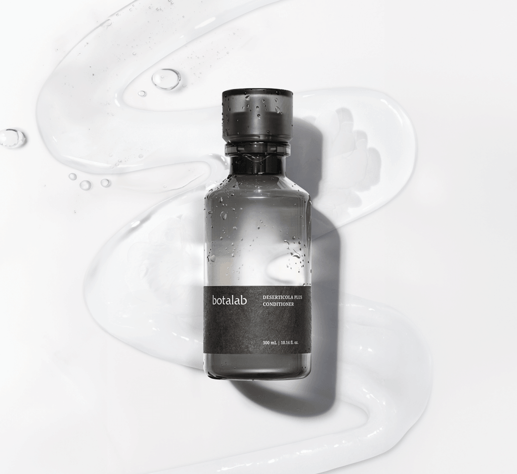 Riman Botalab Deserticola Plus Conditioner bottle on a wavy background with hydrating gel, perfect for hair care.