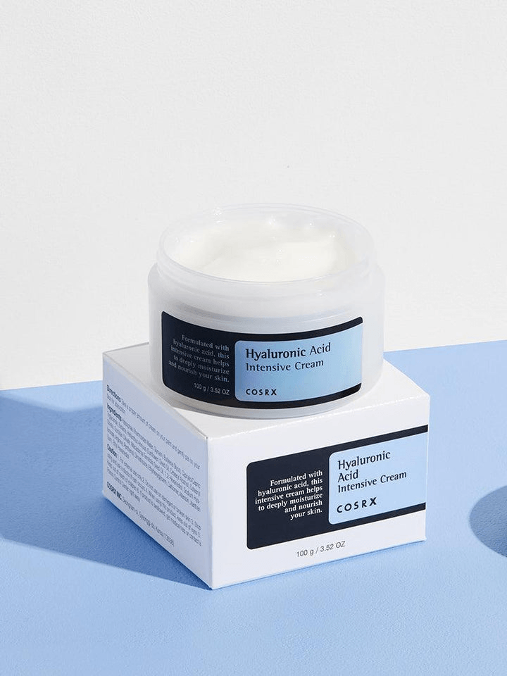 COSRX Hyaluronic Acid Intensive Cream | Korean Moisturizers in a clear jar on a pastel blue background.