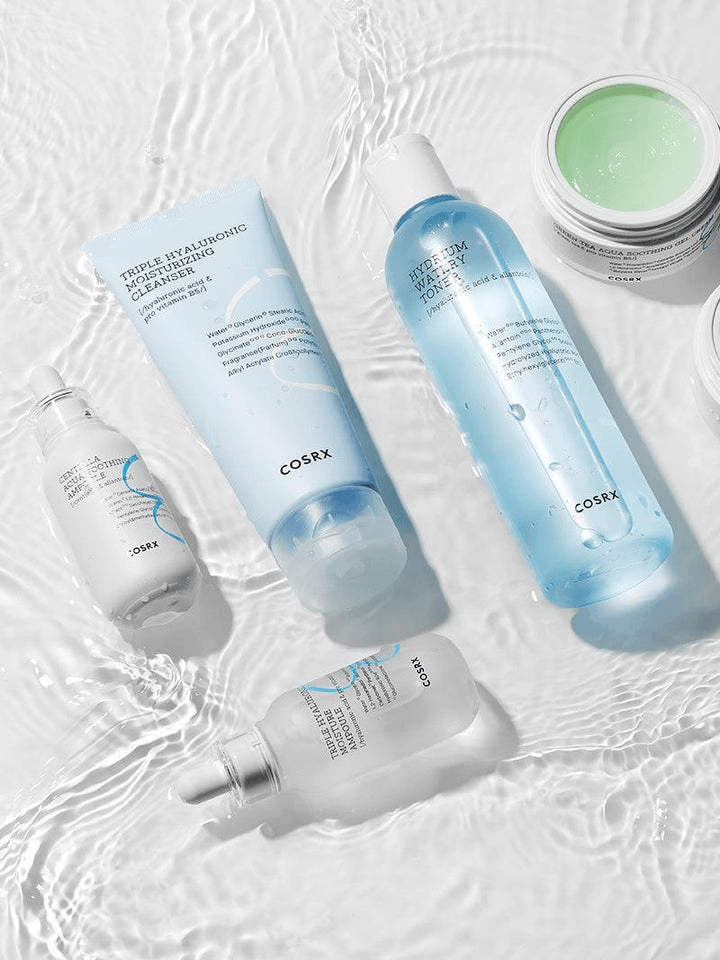 COSRX Triple Hyaluronic Moisturizing Cleanser products displayed on a wet surface, showcasing hydration and cleansing benefits.