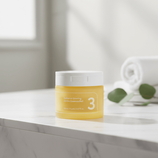 numbuzin No.3 Radiance Glowing Jumbo Essence Pads in a jar on a marble surface with a towel and leaves.